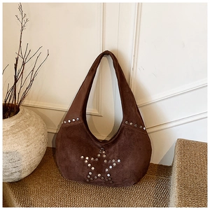 Detailed close-up of dark brown suede hobo bag featuring silver star rivet embellishments