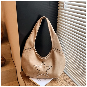 Macro detail of khaki suede shoulder bag featuring silver metal star rivet decorations