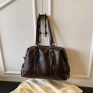 Retro large capacity coffee tote bag in glossy leather hanging on a white cabinet door
