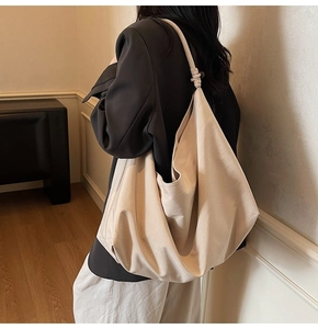 Detail view of cream canvas tote bag with side knot handle and large storage capacity