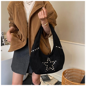 Detail of black suede hobo bag with silver star-shaped rivets and bohemian studs