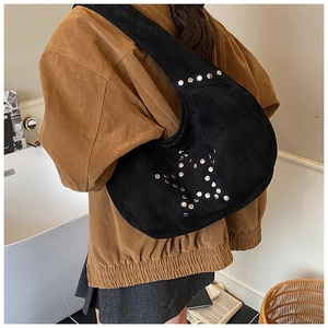 Detail of black suede hobo bag with silver star rivets shown on model shoulder