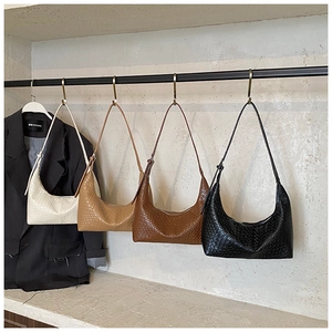Four crescent hobo bags in cream, khaki, brown, and black with woven texture detail