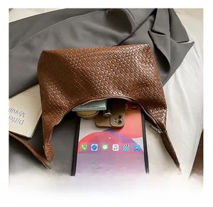 Internal capacity of brown woven shoulder bag with tablet and cosmetics inside