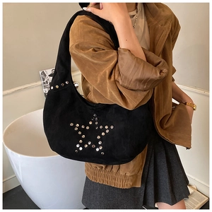 Detail view of black suede hobo bag featuring silver metal star rivets and Y2K aesthetic