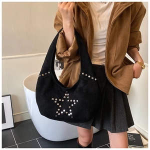 Detail of black suede tote bag with silver metal star rivet decorations and matte finish