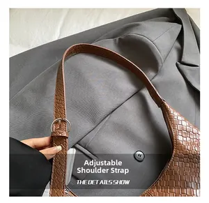 Close-up of woven leather bag detail with adjustable shoulder strap and metal buckle