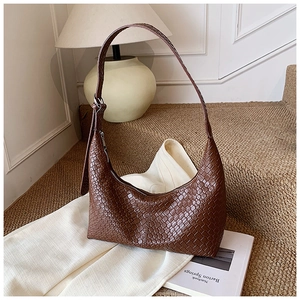 Detail of dark brown woven leather texture on a minimalist hobo shoulder bag