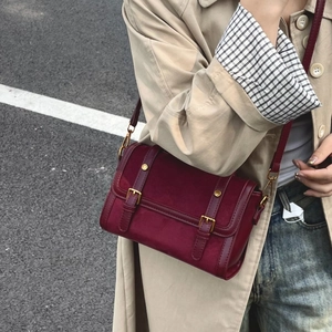 Sac messager bordeaux mat en suédine avec boucles dorées et bandoulière en cuir