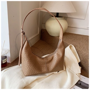 Detailed close-up of brown woven texture and adjustable strap on a vintage hobo bag