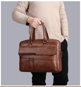 Detailed texture of brown synthetic leather briefcase with metal rings and handle