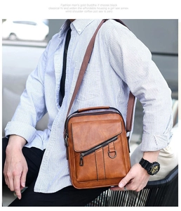 Detail of vintage brown PU leather crossbody bag with metal ring zipper and woven strap