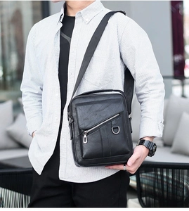Close-up of black PU leather men's crossbody bag with lychee texture and zipper detail