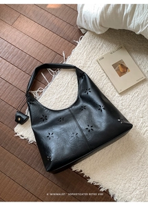 Detail of black laser-cut hollow pattern on hobo bag with matching small coin purse
