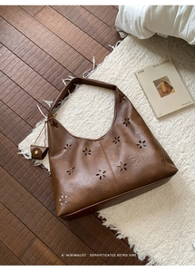 Detailed view of hollowed-out floral pattern on brown retro tote bag with mini pouch