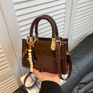 Dark brown leather and suede handbag with woven handle and colorful beaded charm