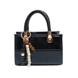 Classic black leather square tote bag with woven handles and beaded fringe charm detail