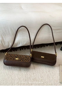Detail of minimalist underarm bags in brown faux suede and chic leopard print textures