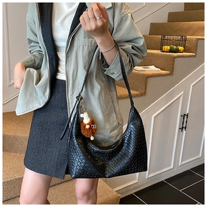 Detail showing the black crocodile embossed texture and plush charm of this hobo bag
