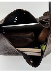 Top view of large dark brown tote bag interior with laptop and books showing storage