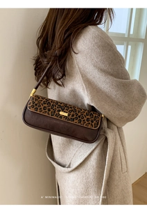 Detail of retro leopard print and brown leather shoulder bag with gold metal buckle