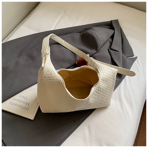 Detail view of woven shoulder bag texture with beige leather finish and zipper closure