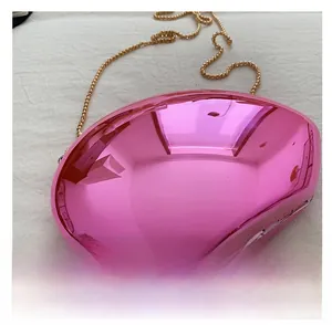 Detail of pink metallic shell-shaped acrylic mini bag with a fine gold chain strap