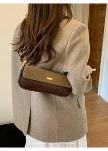 Close-up of minimalist retro bag showing dark brown and olive green matte leather detail