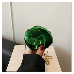Detail of metallic green spherical clutch bag with golden chain strap for evening party