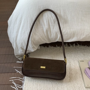 Detail of dark coffee underarm bag featuring vintage suede texture and gold metal buckle