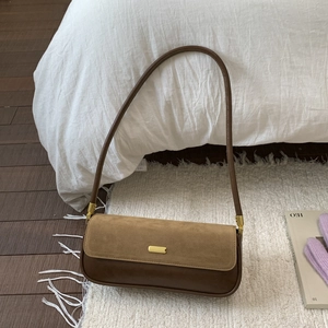 Close-up of a vintage baguette underarm bag with khaki suede flap and gold buckle detail
