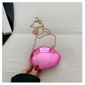 Detail of pink metallic shell-shaped clutch bag with elegant golden chain strap