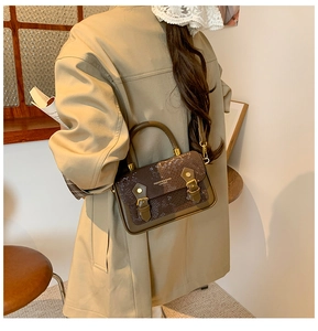 Rear view of brown faux snake skin leather bag on model in a cozy interior setting