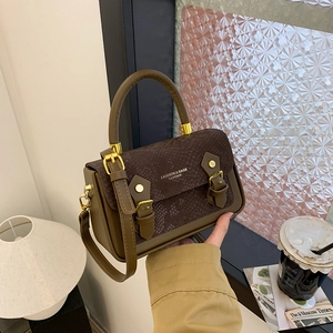 Close-up of retro brown snakeskin handbag with golden hardware on a vintage wooden table