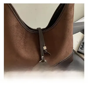 Detail of vintage brown suede shoulder bag showing silver hardware and premium stitching