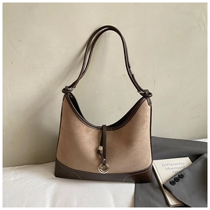 Detail of khaki suede hobo bag with dark brown leather piping and metal ring decor