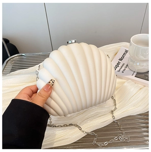 Close-up of white shell-shaped acrylic bag with silver hardware and sleek metal chain