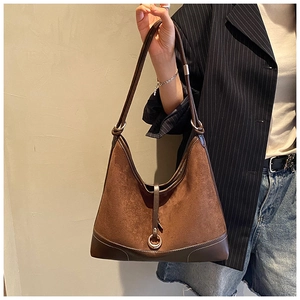 Detail of vintage brown suede hobo bag shown with a striped suit for daily style