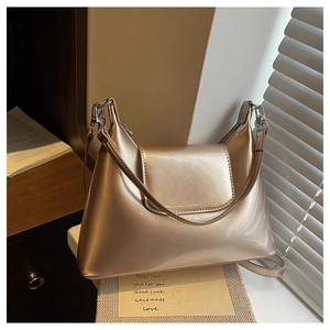 Detail of champagne gold metallic leather handbag with dual straps and silver hardware