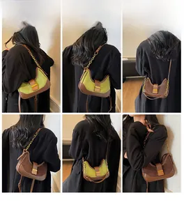 Detail view of olive green and brown suede crossbody bag with gold metal chain strap