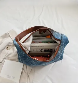 Detail shot of blue denim tote bag with star pattern and spacious interior for essentials