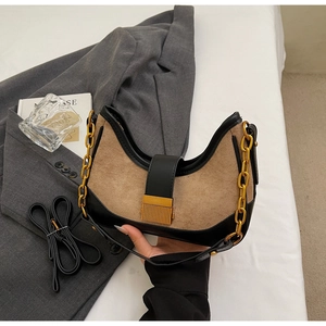 Detail of khaki suede saddle bag with black leather trim and gold chain strap