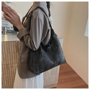 Detail of black sparkling hobo bag with shimmering sequins and leather shoulder strap