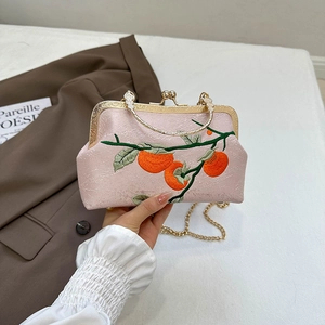 Vintage pink embroidered crossbody bag with floral pattern and gold metal frame handle