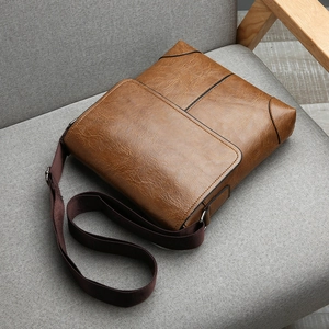 Detail of vintage brown leather texture and stitching on men's crossbody bag