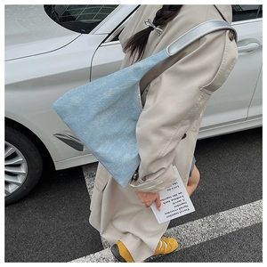 Close-up of light blue textured canvas tote bag with a metallic silver shoulder strap