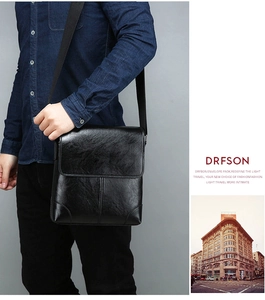 Polished leather texture of a black crossbody envelope bag with adjustable shoulder strap