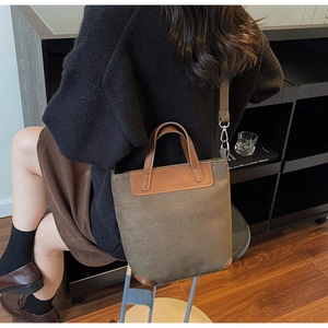 Detail of vintage canvas and leather tote bag with adjustable shoulder strap and handles