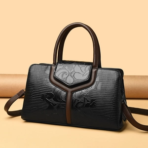 Borsa nera con trama a coccodrillo, goffratura floreale e tracolla marrone