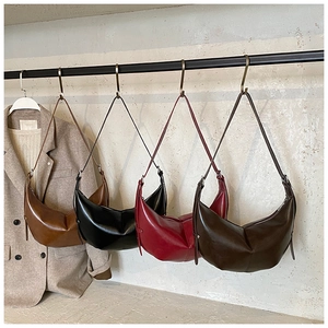 Sacs hobo en caramel, noir, rouge foncé et café suspendus sur un support en métal